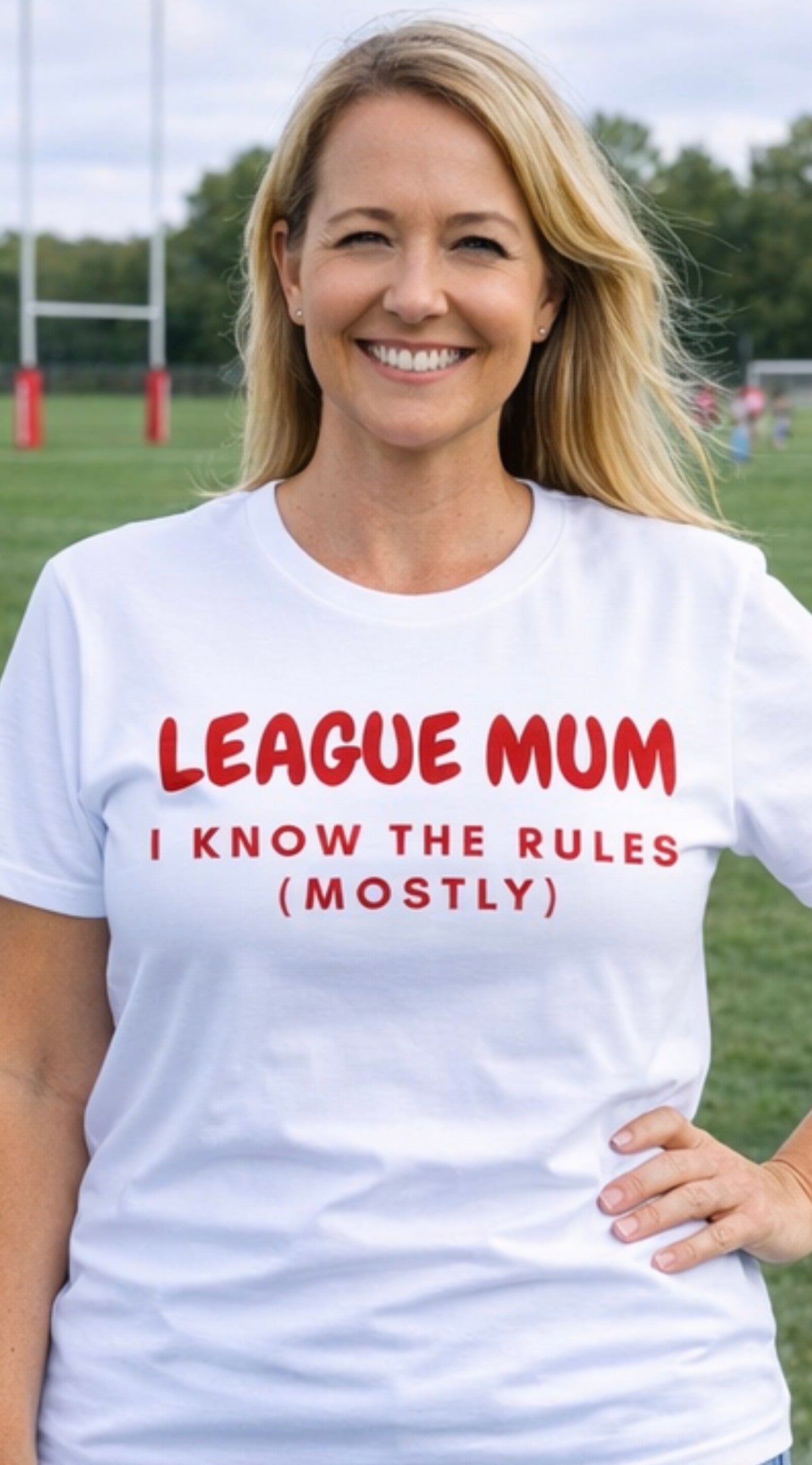 Woman wearing a white t-shirt with red text on a sports field