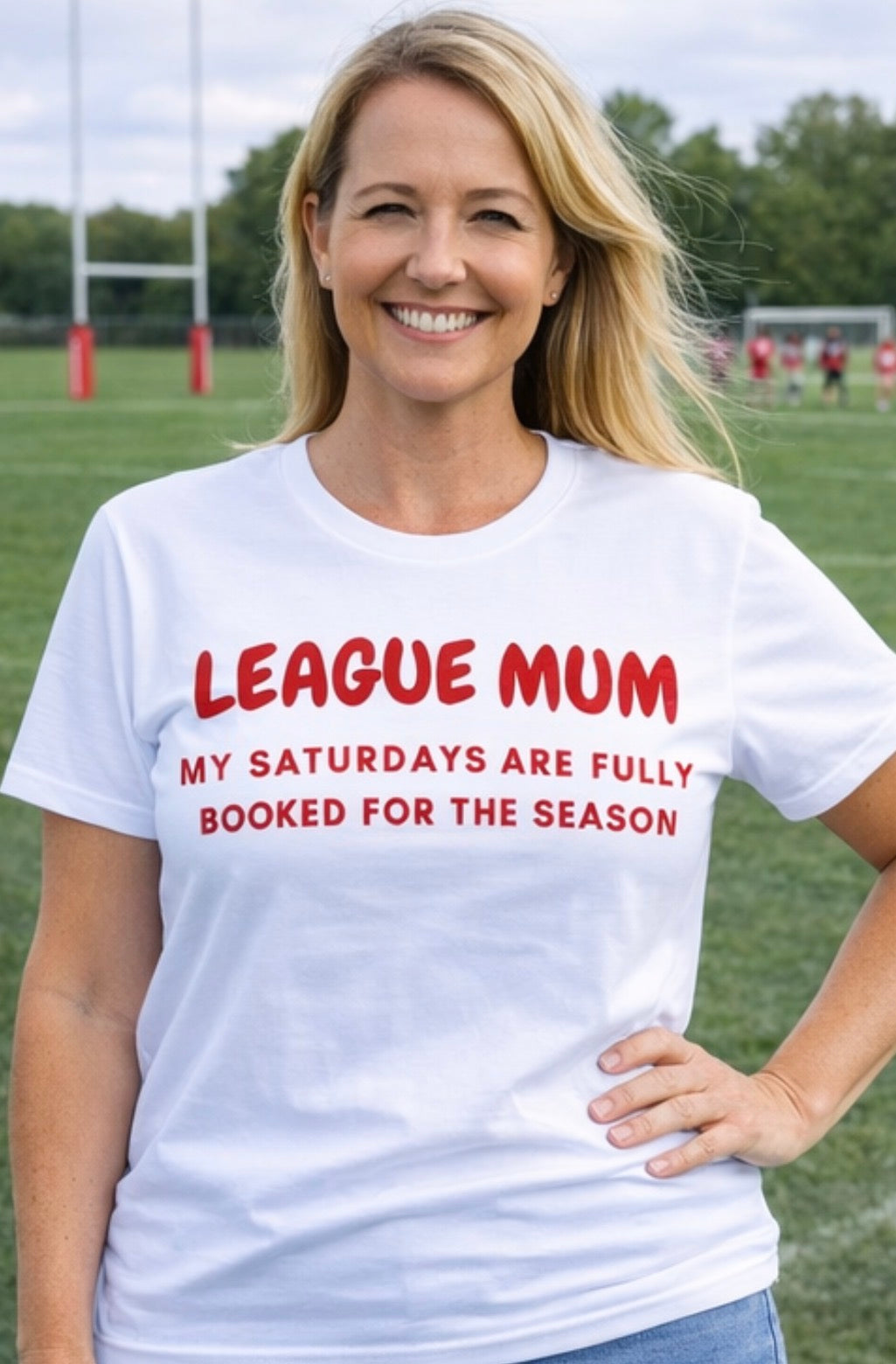 Woman wearing a white t-shirt with red text on a sports field