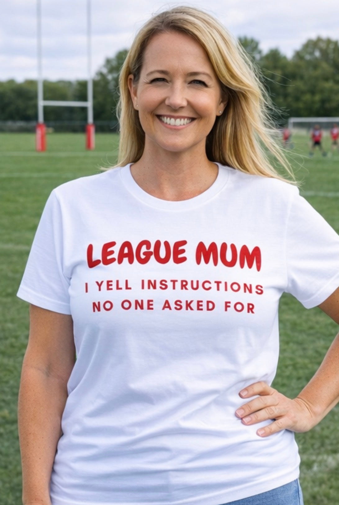 Woman wearing a white t-shirt with red text on a sports field