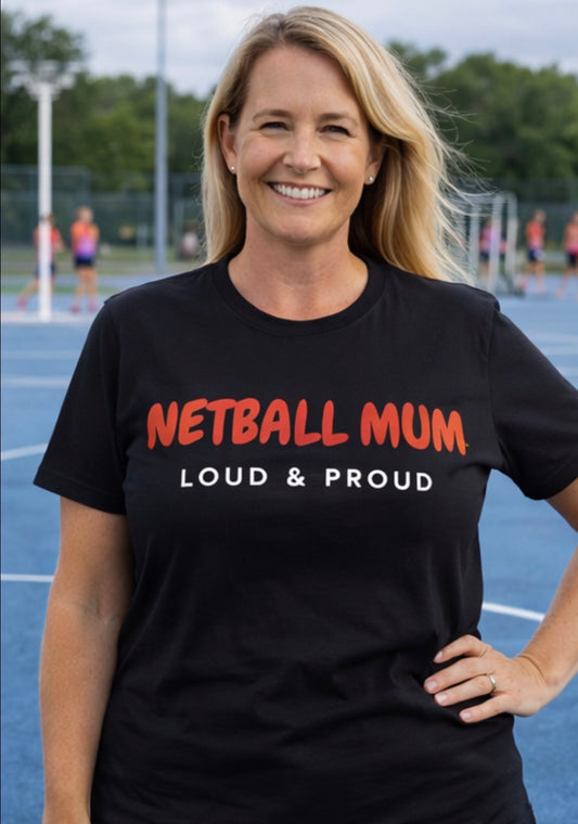 Woman wearing a black t-shirt with 'NETBALL MUM LOUD & PROUD' text on a sports court.